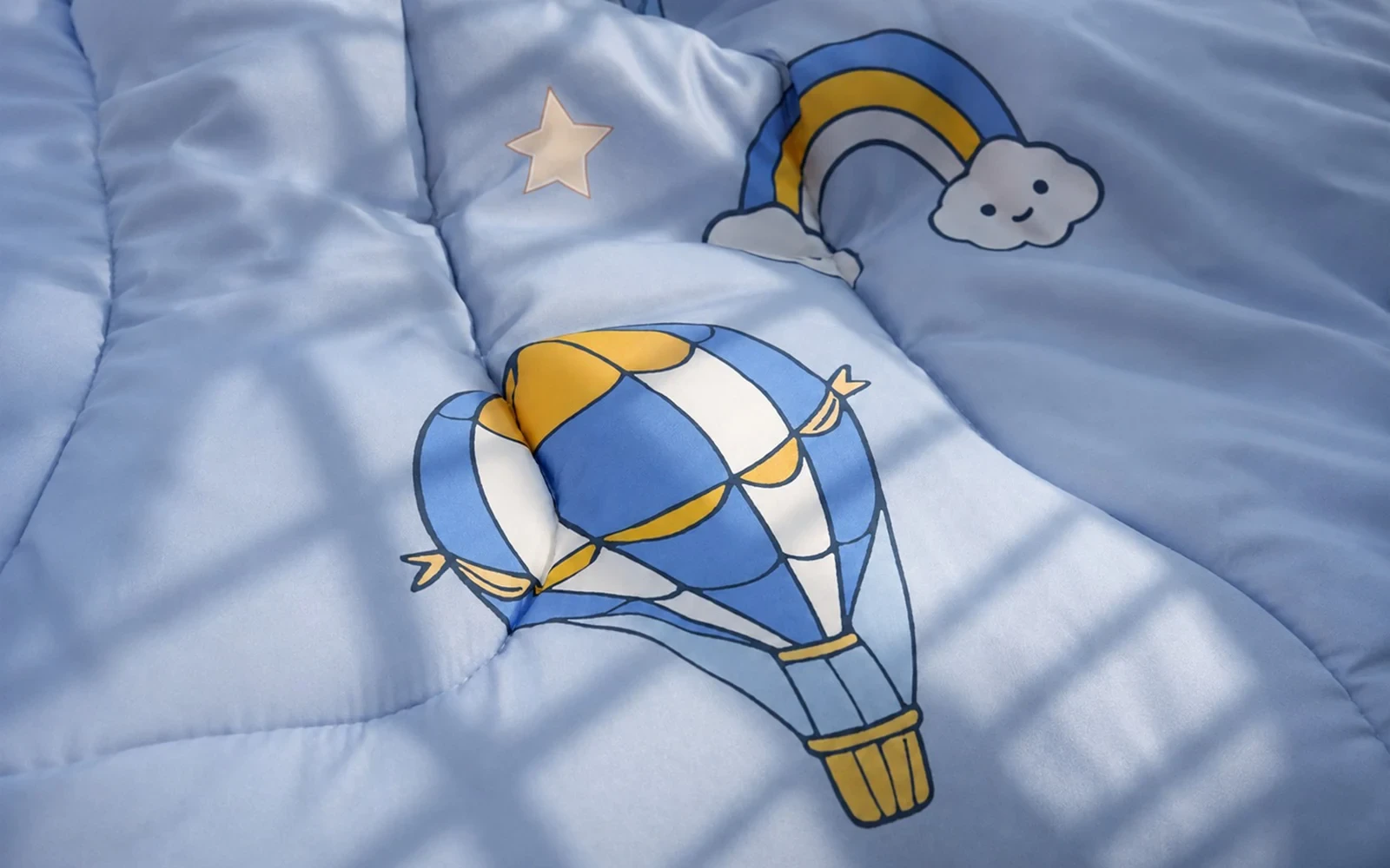 Close-up of blue kids bedding with hot-air balloon and star prints